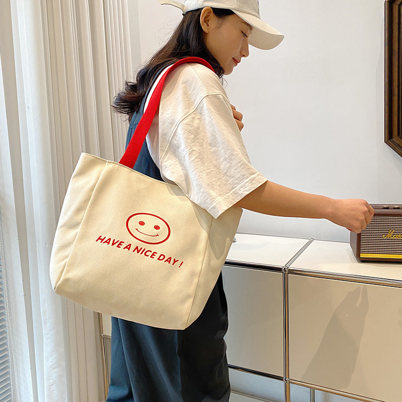 လက်ကား Smiley Face Tote Bag ကြီးမားသောစွမ်းရည်အိတ် အမျိုးသမီးများ 2023 စွယ်စုံရပခုံးအိတ် ကျောင်းသား ကျူတိုရီရယ်အိတ်အသစ် 