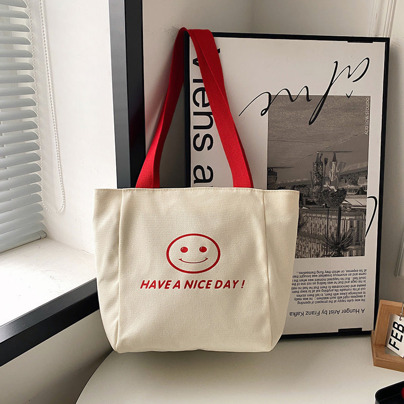 လက်ကား Smiley Face Tote Bag ကြီးမားသောစွမ်းရည်အိတ် အမျိုးသမီးများ 2023 စွယ်စုံရပခုံးအိတ် ကျောင်းသား ကျူတိုရီရယ်အိတ်အသစ် 